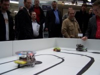 Besucher beobachten die Roboter auf dem Spielfeld